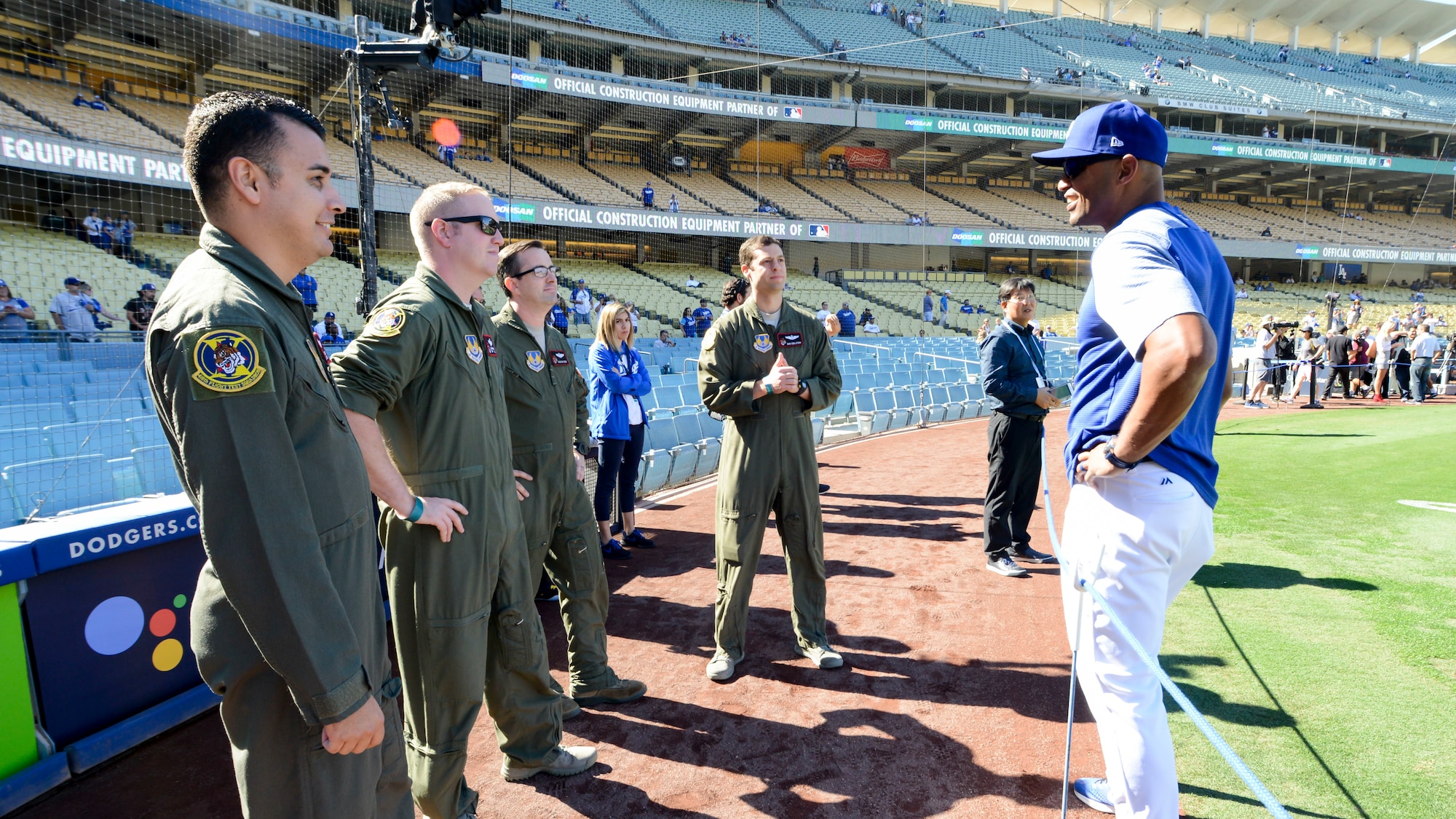 Tech. Sgt. Robert Villa, Master Sgt. Caleb Patterson, Maj. Duncan Reed and Maj. Dan Edelstein, all with 418th Flight Test Squadron, 412th Test Wing, talks with Los Angeles Dodgers first base coach George Lombard prior to Game 3 of Major League Baseball’s National League Championship Series between the Los Angeles Dodgers and Milwaukee Brewers at Dodger Stadium in Los Angeles, California, Oct. 15. (U.S. Air Force photo by Giancarlo Casem)