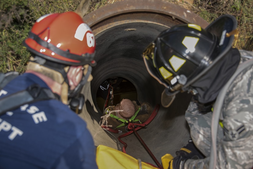 87th Civil Engineer Squadron Airmen pull a training dummy out of a tunnel during a confined space and safety inspection exercise on Joint Base McGuire-Dix-Lakehurst, New Jersey, Oct. 3, 2018. This was the first inspection of its kind, veering the department toward a new direction of training to make use of the joint work environment. The exercise brought different agencies from around the base together to work as a team. (U.S. Air Force photo by Airman First Class Ariel Owings)