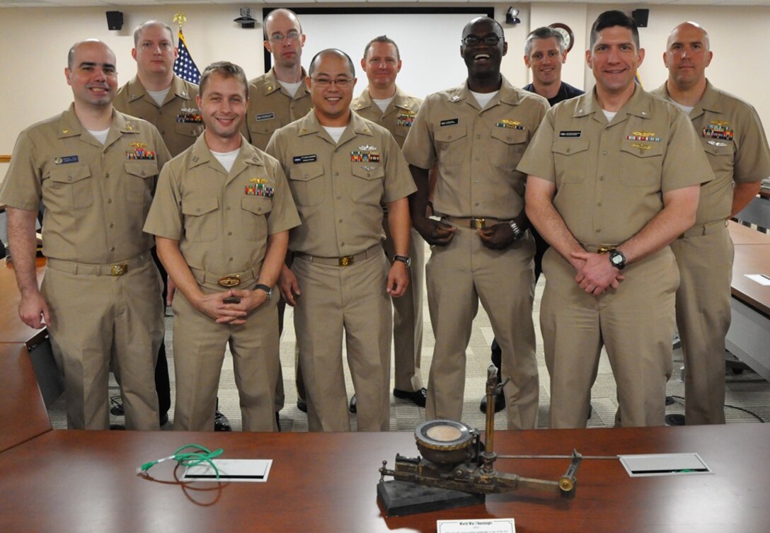 IMAGE: DAHLGREN, Va. (Oct. 12, 2018) - Naval Surface Warfare Center Dahlgren Division (NSWCDD) military personnel are pictured in front of a World War I bombsight - used to conduct testing at the Dahlgren Naval Proving Ground in the 1920s and 1930s - during a celebration of the Navy's 243rd birthday. The aircraft course-setting bombsight is one of the few surviving examples of the many bombsights tested at Dahlgren. NSWCDD will celebrate 100 years of cutting-edge technological innovation in support of the warfighter at a centennial grand finale Oct. 19 that includes an exhibition tent, a U.S. Navy Band performance, and historic tours featuring six station stops on base. Front row, left to right, are Lt. Cmdr Michael Tozzi, Lt. Adam Mattison, Chief Cryptologic Technician (Technical) Joshua Schroeder, Lt. Akwasi Fosu, and Cmdr. Steven Perchalski. Back row, left to right, are Fire Controlman (Aegis) 1st Class James Flett, Lt. Cmdr. Thomas Pilkerton, Lt. Cmdr. David Rackley, British Royal Navy Lt. Cmdr. Richard Bowen, and Chief Warrant Officer (CWO2) Jason Tillman.