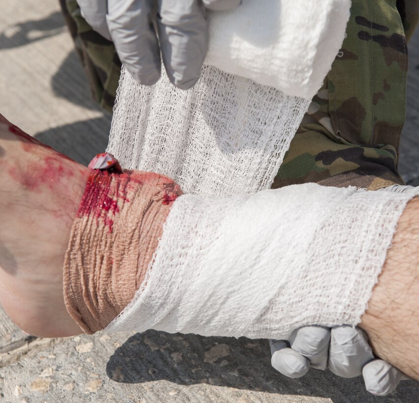U.S. Air Force (USAF) Tech. Sgt. Fred Forero, 28th Expeditionary Air Refueling Squadron aerospace medical technician, wraps the ankle of USAF Tech. Sgt. Trevor Gaskins, 379th Expeditionary Medical Support Squadron medical technician, during exercise Atlas Mountain (AM) at Al Udeid Air Base, Qatar, Oct. 16, 2018.
