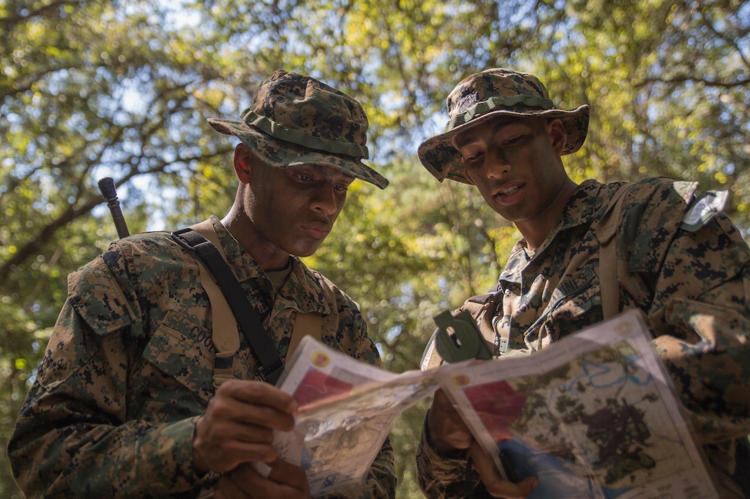 Recruits with Mike Company, 3rd Recruit Training Battalion, examine and plot points on their maps during the land navigation course at Elliot’s Beach on Marine Corps Recruit Depot, Parris Island, S.C., Oct. 04, 2018. The Land Navigation Course teaches recruits how to properly navigate unfamiliar terrain. (U.S. Marine Corps photo by Cpl. Vivien Alstad)