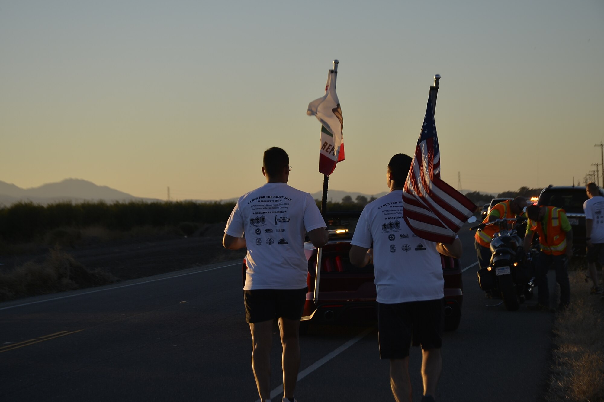 Two members of the 7th Annual California Run for the Fallen Honor Run team carry the U.S. and California flags as they run through Lodi, Calif., Oct. 13, 2018. The event consists of a 150-mile run through 23 towns. At every mile, runners placed American flags, known as ‘hero markers,’ in the ground to honor California service members who made the ultimate sacrifice since 9/11. (Courtesy Photo)