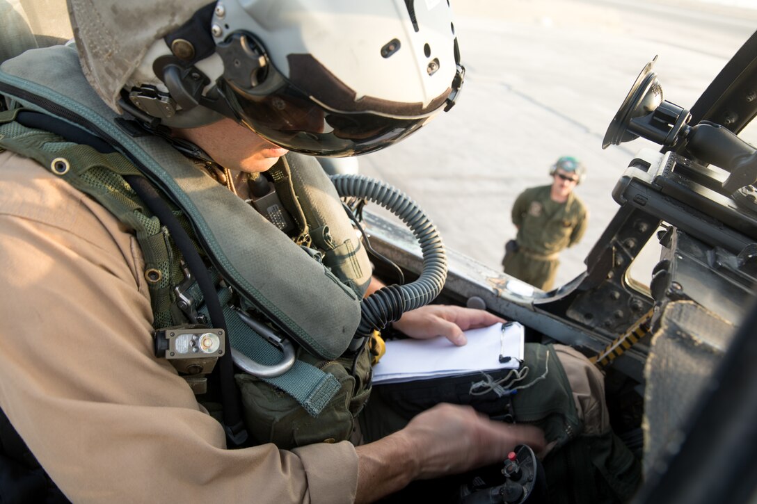 UNDISCLOSED LOCATION, SOUTHWEST ASIA -- U.S. Marine Corps Maj. Scott Symons, a pilot of an F/A-18 Hornet assigned to Marine Fighter Attack Squadron 115, Marine Aircraft Group 31, 2nd Marine Aircraft Wing, prepares his notepad prior to takeoff. The pilots of the F/A-18 provide aerial security for the Marines on the ground while providing a close air support for the Special Purpose Marine Air-Ground Task Force, Crisis Response-Central Command. (U.S. Marine Corps photo by Cpl. Roderick Jacquote)