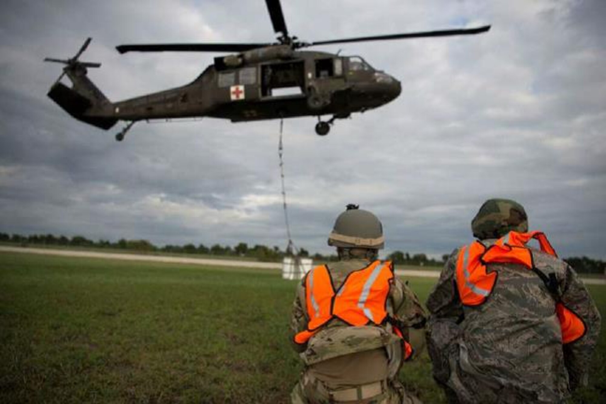 Capt. Nathan Del Rio (left) and 2nd Lt Brandon Smolinski (right) monitor the extraction of a 2,000 pound A-22 cargo bag of supplies