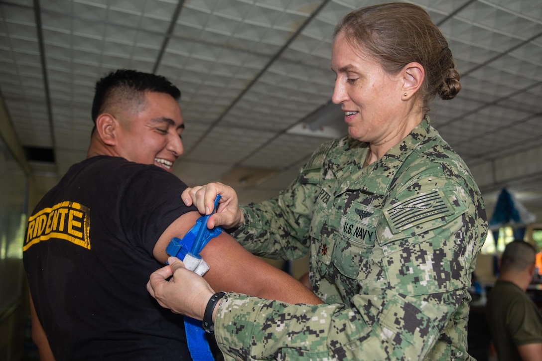 A U.S. Navy doctor  participates in a tourniquet application drill as part of a subject matter expert exchange with Salvadoran military professionals.