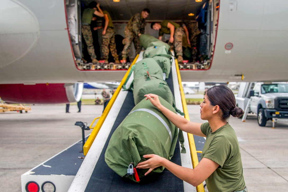 Marines load bags onto an aircraft.