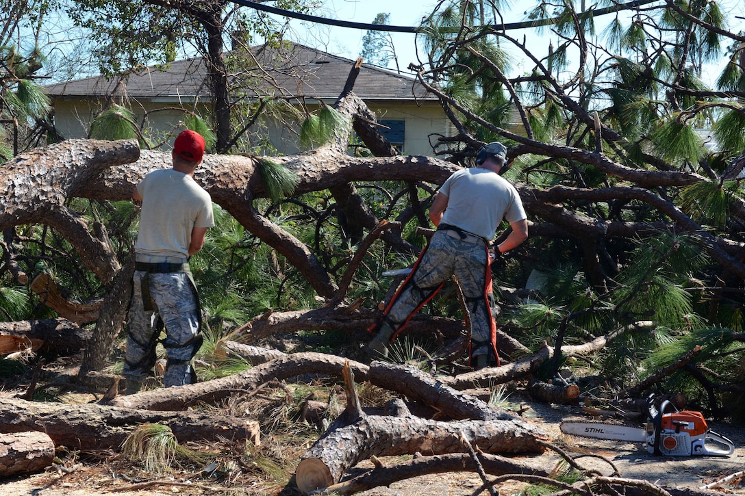 Airmen use chain saws to clear fallen trees in neighborhoods near the 10 Mile Road area in Panama City.