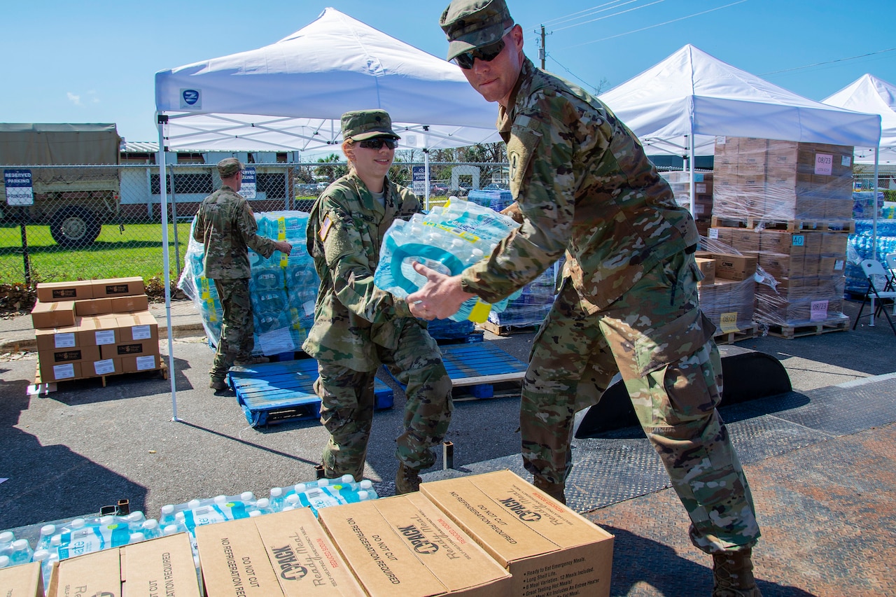 Soldiers distribute water and supplies to residents in need following Hurricane Michael.