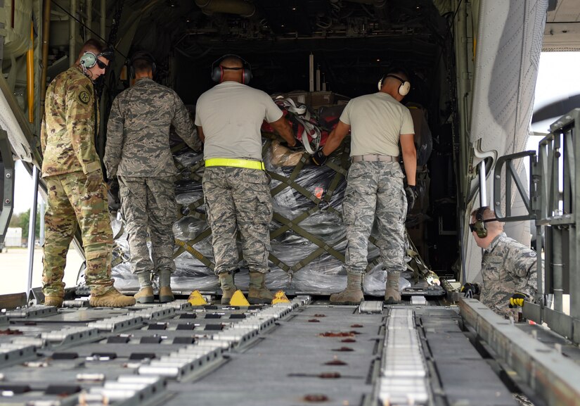 U.S. Air Force Airmen from the 733rd Logistics Readiness Squadron small air terminal assist the 71st Rescue Squadron loadmasters with the gear and supplies being sent to Tyndall Air Force Base, Florida, onto a HC-130J Combat King II at  Joint Base Langley-Eustis, Virginia, Oct. 17, 2018. The HC-130J is from the 71st Rescue Squadron at Moody Air Force Base, Georgia. (U.S. Air Force photo by Staff Sgt. Carlin Leslie/Released)