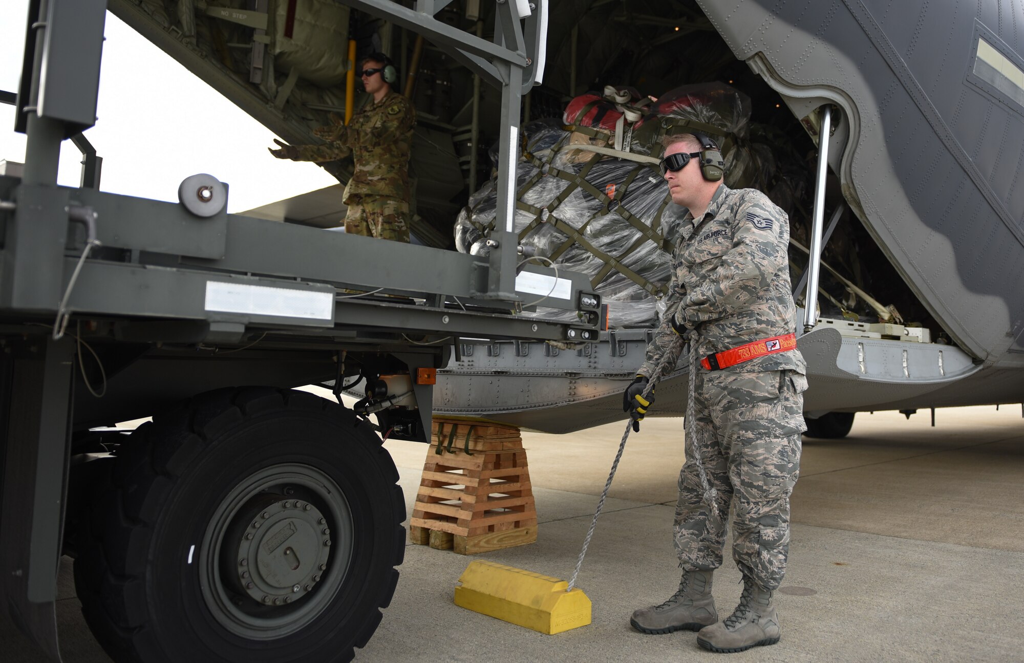 U.S. Air Force Staff Sgt. John Wilson, 733rd Logistics Readiness Squadron deployment readiness, waits for the order to pull chaulks during a loading operation supporting the Tyndall Air Force Base, Florida, recovery efforts at Joint Base Langley-Eustis, Virginia, Oct. 17, 2018. The HC130J Combat King II is from the 71st Rescue Squadron at Moody Air Force Base, Georgia. (U.S. Air Force photo by Staff Sgt. Carlin Leslie/Released)