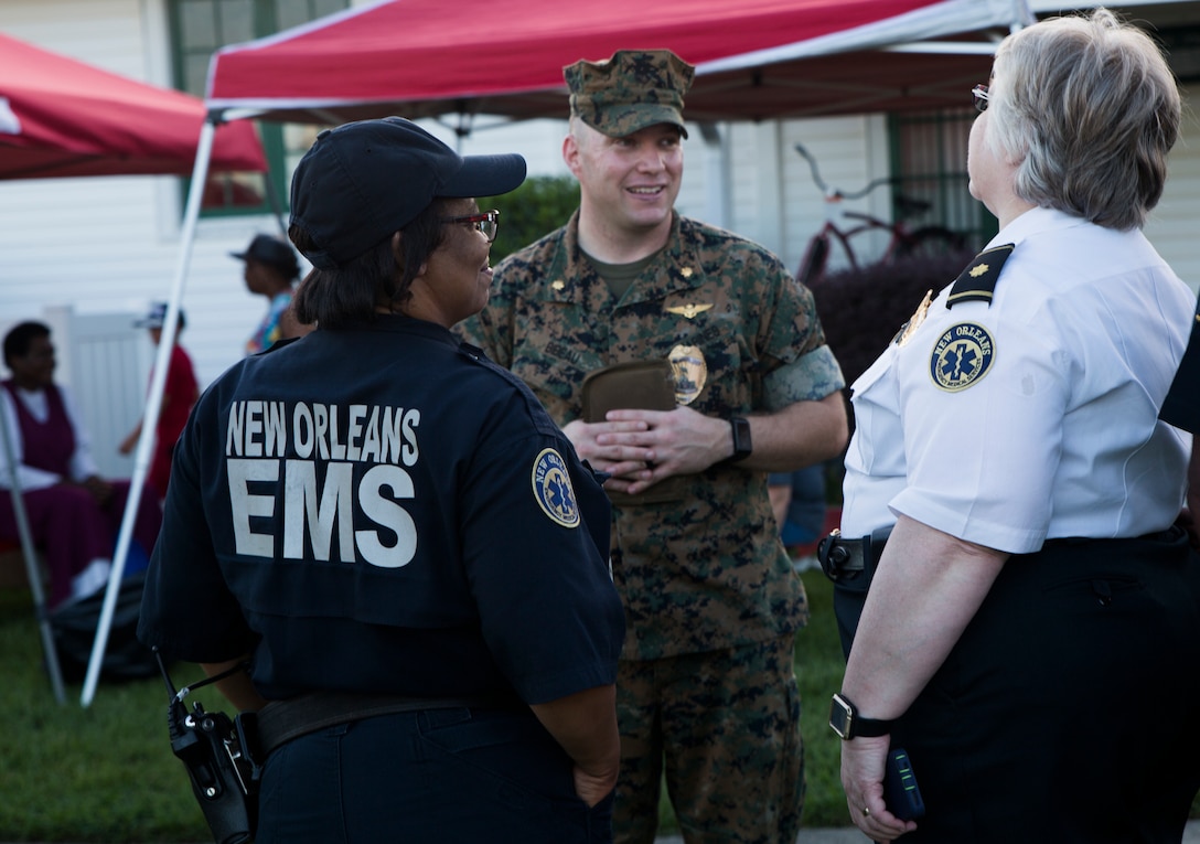 Maj. Christopher M. Bibeau, the Marine Corps Support Facility New Orleans Provost Marshal, speaks with members of the New Orleans Emergency Medical Services during the annual “Night Out Against Crime” held at the Village at Federal City, New Orleans, Oct. 16, 2018.  “Night Out Against Crime” is a yearly event in which Marines, officers within the New Orleans Police Department and other first responders come together with community members to raise awareness of police officer presence. (U.S. Marine Corps photo by Sgt. Melissa Martens)