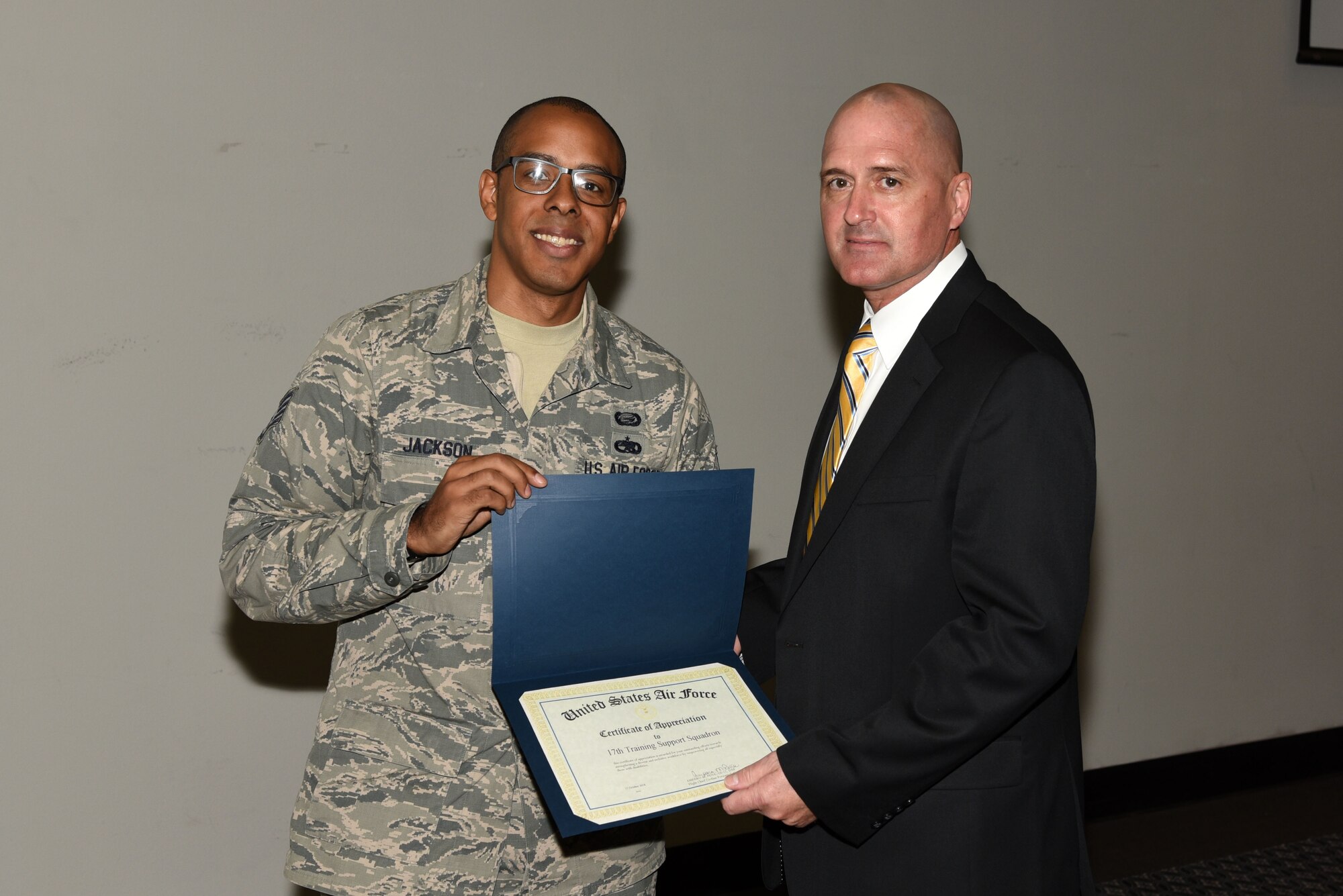 U.S. Air Force Staff Sgt. Layne Jackson, 17th Training Wing Equal Opportunity adviser, presents 17th Training Support Squadron Director of Operations, Joseph Gomos, with a certificate of appreciation during the National Disability Employment Awareness Month info fair at the Event Center on Goodfellow Air Force Base, Texas, Oct. 17, 2018. The certificate was for the 17th TRSS’s support of workers with disabilities. (U.S. Air Force photo by Staff Sgt. Joshua Edwards/Released)