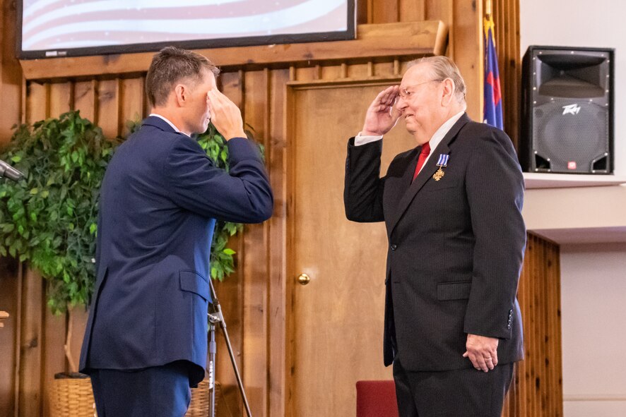 David Miller salutes U.S. Air Force Col. Ryan D. Blake, 412th Test Pilot School commandant, Edwards AFB California, Oct. 13, 2018. Miller received the Distinguished Flying Cross nearly 50 years after earning the medal during his tour in Vietnam. Blake is a longtime family friend of the Millers having grown up with Miller’s children.(U.S. Air Force photo by Tech. Sgt. Cody Burt)