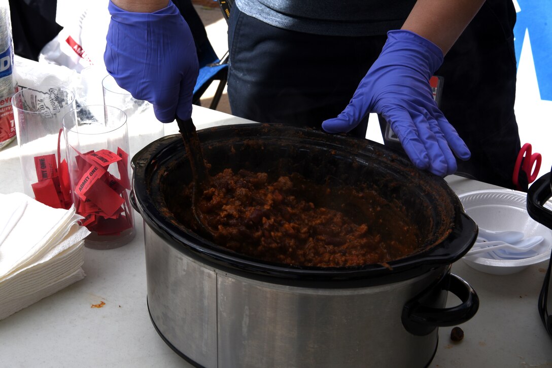 A local volunteer serves chilli as part of a chilli cook-off.The F.E. Warren Air Force Base fire department won the competition. The local community enjoys the festivities during the Fire Prevention Week Open House at Cheyenne, Wyo., Oct. 13, 2018.