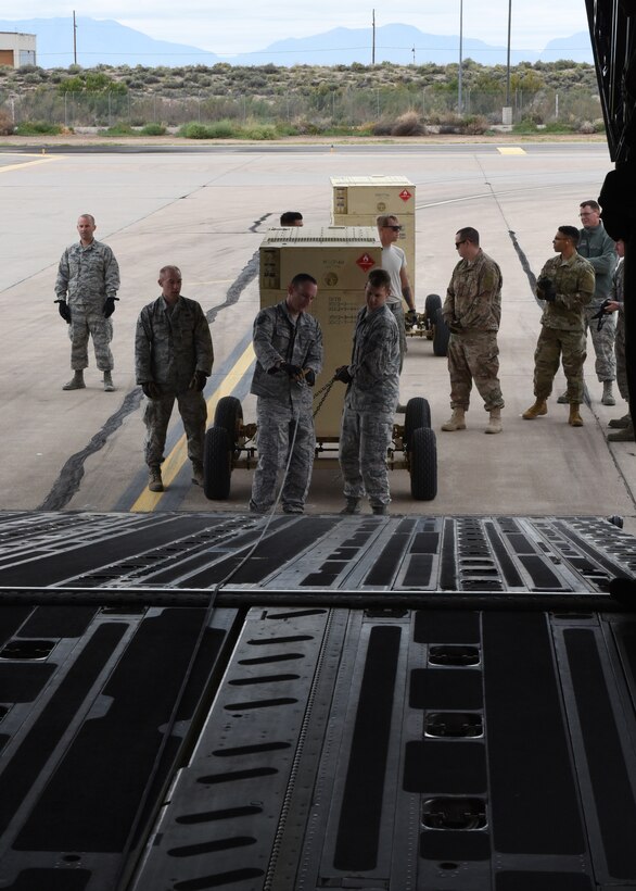 Airmen from the 49th Logistics Readiness Squadron and the 635th Materiel Maintenance Group lock equipment into place, Oct. 15, 2018, on a C-17 Globemaster III, assisted to the Memphis Air National Guard, on the flightline at Holloman Air Force Base, N.M. The 49th LRS supported Airmen from the 635th MMG in a recent operation to send essential supplies to Tyndall Air Force Base, Fla. (U.S. Air Force photo by Airman Autumn Vogt)