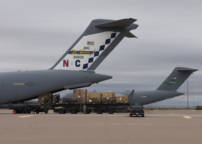 Airmen from the 49th Logistics Readiness Squadron and the 635th Materiel Maintenance Group lock equipment into place, Oct. 15, 2018, on a C-17 Globemaster III, assisted to the Memphis Air National Guard, on the flightline at Holloman Air Force Base, N.M. The 49th LRS supported Airmen from the 635th MMG in a recent operation to send essential supplies to Tyndall Air Force Base, Fla. (U.S. Air Force photo by Airman Autumn Vogt)
