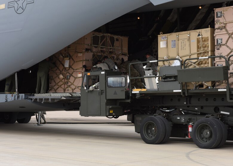 Airmen from the 49th Logistics Readiness Squadron and the 635th Materiel Maintenance Group lock equipment into place, Oct. 15, 2018, on a C-17 Globemaster III, assisted to the Memphis Air National Guard, on the flightline at Holloman Air Force Base, N.M. The 49th LRS supported Airmen from the 635th MMG in a recent operation to send essential supplies to Tyndall Air Force Base, Fla. (U.S. Air Force photo by Airman Autumn Vogt)