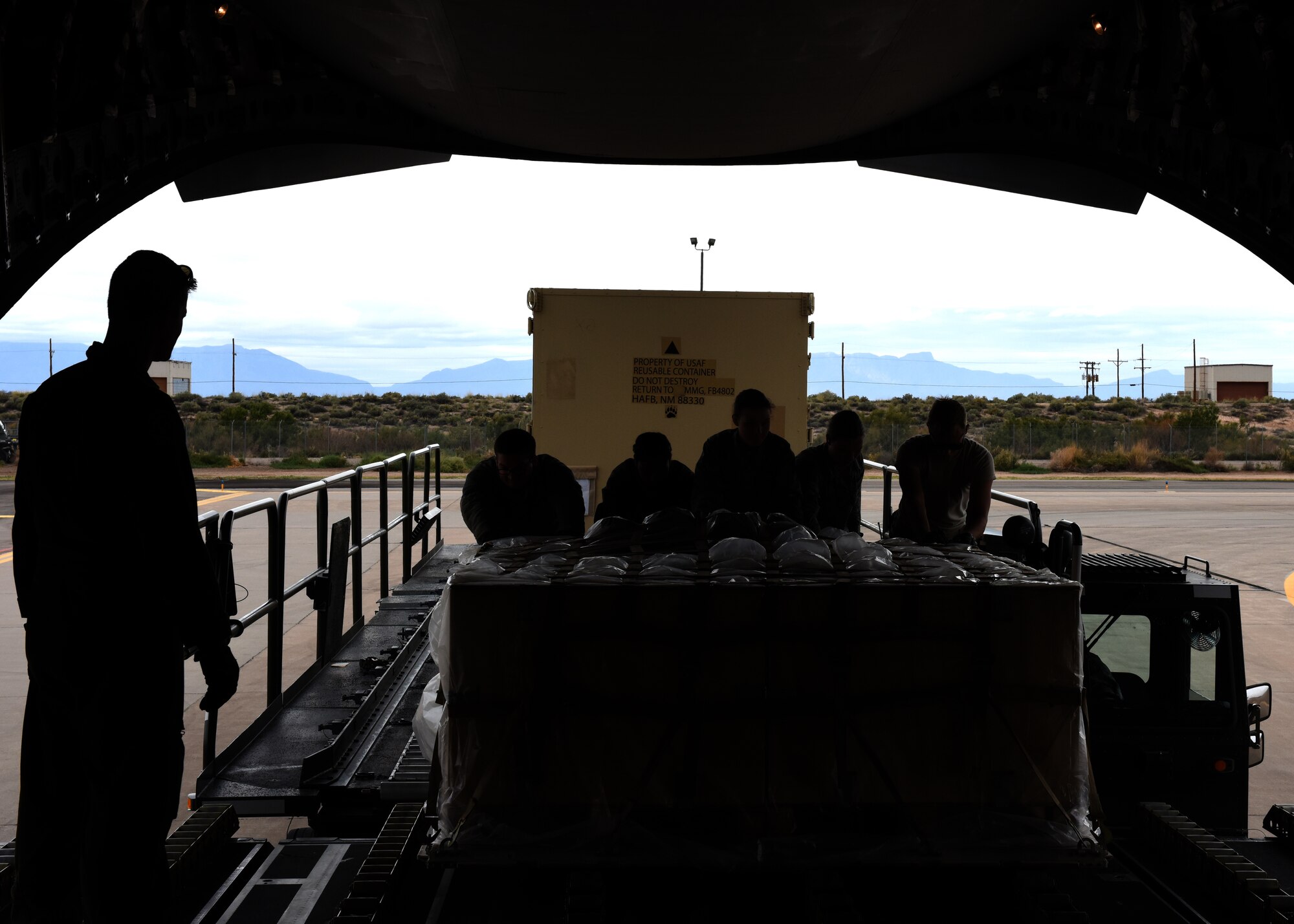 Airmen from the 49th Logistics Readiness Squadron and the 635th Materiel Maintenance Group lock equipment into place, Oct. 15, 2018, on a C-17 Globemaster III, assisted to the Memphis Air National Guard, on the flightline at Holloman Air Force Base, N.M. The 49th LRS supported Airmen from the 635th MMG in a recent operation to send essential supplies to Tyndall Air Force Base, Fla. (U.S. Air Force photo by Airman Autumn Vogt)