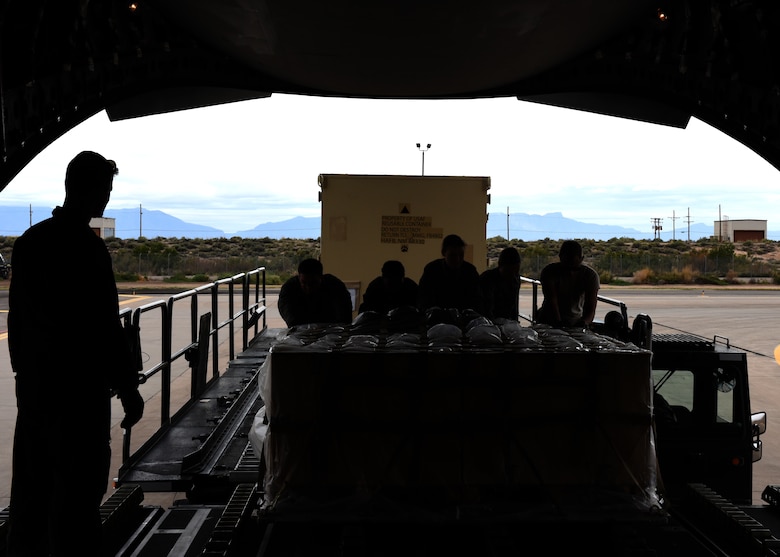 Airmen from the 49th Logistics Readiness Squadron and the 635th Materiel Maintenance Group lock equipment into place, Oct. 15, 2018, on a C-17 Globemaster III, assisted to the Memphis Air National Guard, on the flightline at Holloman Air Force Base, N.M. The 49th LRS supported Airmen from the 635th MMG in a recent operation to send essential supplies to Tyndall Air Force Base, Fla. (U.S. Air Force photo by Airman Autumn Vogt)