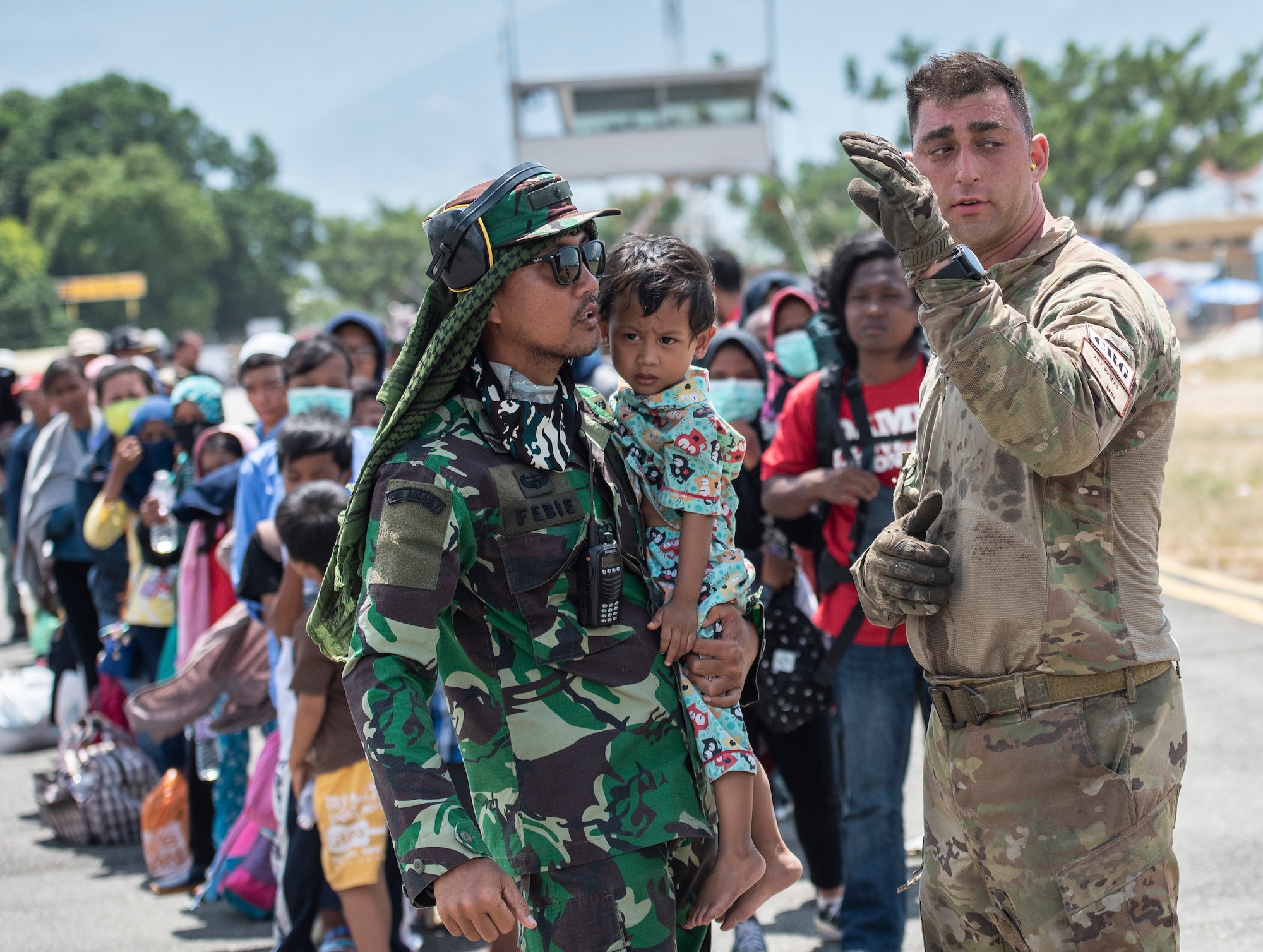 U.S. Air Force Staff Sgt. Michael Mendes, 36th Mobility Response Squadron loadmaster, assists an Indonesian soldier and child with instructions before boarding a Republic of Singapore Air Force C-130 in Palu, Indonesia Oct. 10, 2018, The Indonesian Government and U.S. Agency for International Development are working alongside 15 countries agencies and foreign militaries ensuring supplies, airlift, shelter and medical support reach those affected. (U.S. Air Force photo by Master Sgt. JT May III)