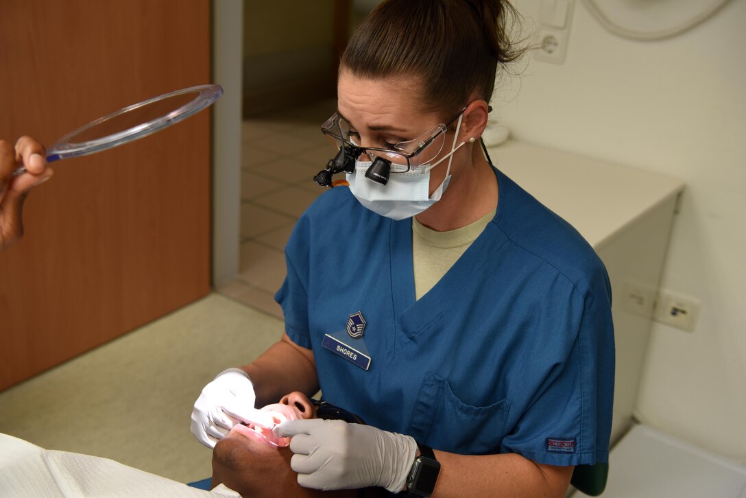 Master Sgt. Kara Shores, 86th Dental Squadron Chief of Preventive Dentistry, flosses Airman 1st Class Blake Duty’s teeth, showing part of the annual teeth cleaning procedure. Dental Hygiene month celebrates the work dental hygienists do and helps raise awareness on the importance of good oral health.