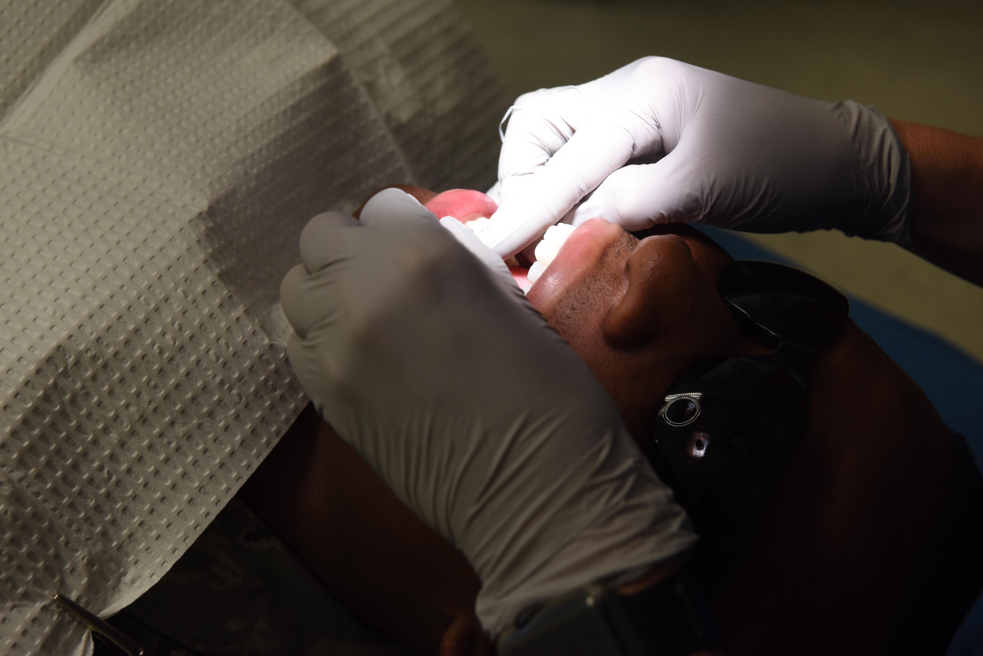 Airman 1st Class Blake Duty, 86th Dental Squadron periodontal technician, sits in a dental chair to show what patients would experience during a routine teeth cleaning. The on base dental clinic provides examinations and cleanings once per year for active duty military, unless a patient has other periodontal needs.