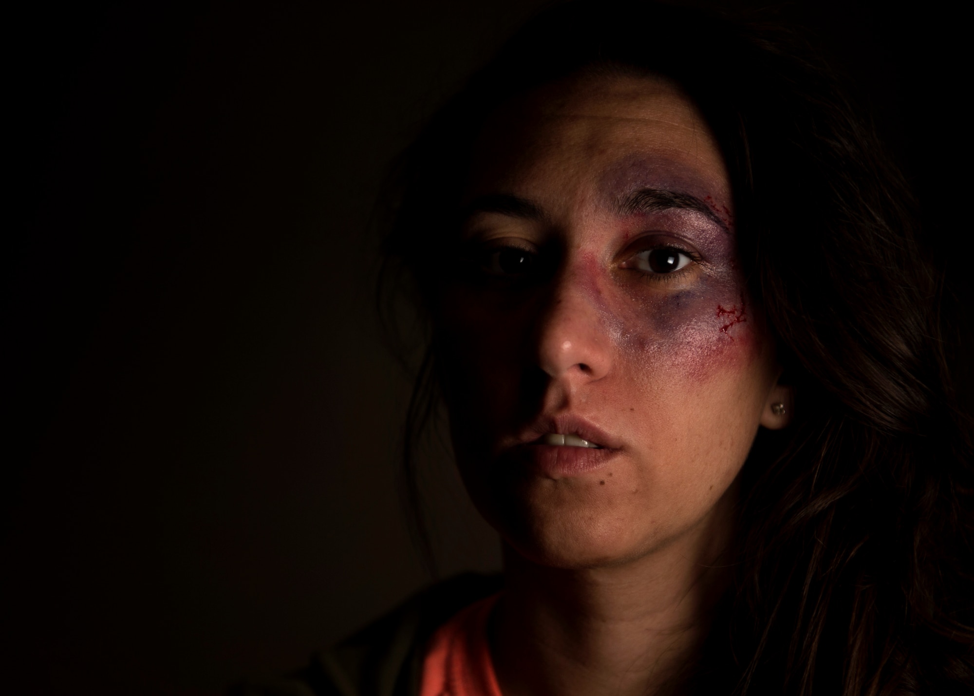 U.S. Air Force Staff Sgt. Ashley Payne, 726th Air Mobility Squadron command support staff NCO in charge, poses for a portrait while wearing moulage makeup at Spangdahlem Air Base, Germany, Oct. 17, 2018. Payne volunteered to simulate a victim of domestic violence for one day in support of the Black Eye Campaign. The social experiment was designed to keep track of how many people responded to signs of abuse. (U.S. Air Force photo by Airman 1st Class Valerie Seelye)
