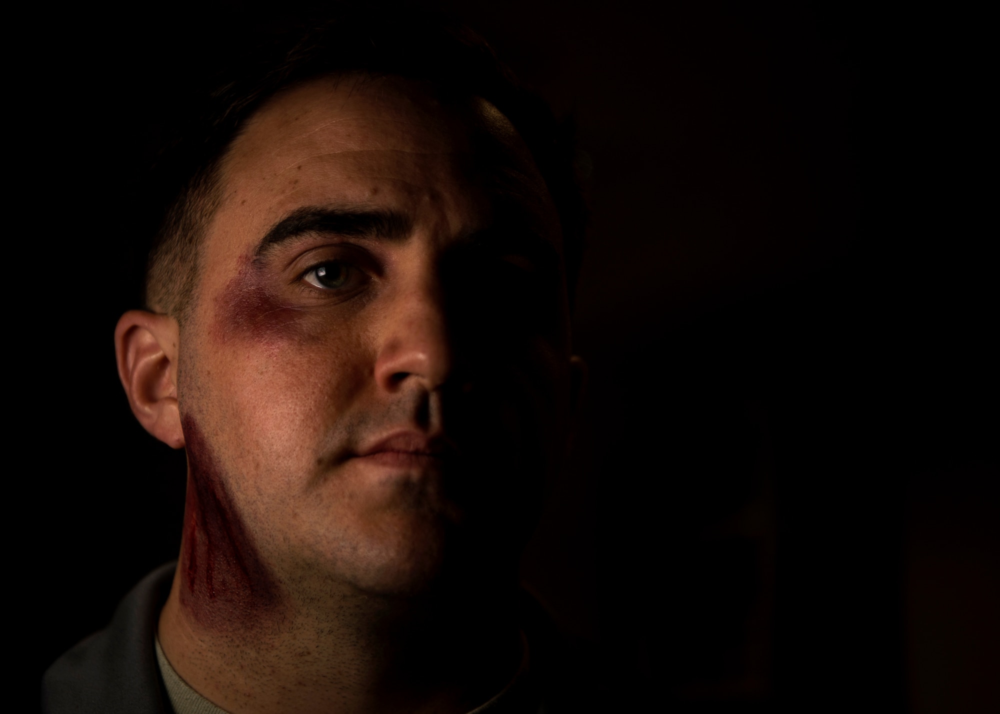 U.S. Air Force Staff Sgt. William Marshall, 52nd Communications Squadron mission defense team NCO in-charge, poses for a portrait while wearing moulage makeup at Spangdahlem Air Base, Germany, Oct. 17, 2018. Marshall volunteered to simulate a victim of domestic violence for one day in support of the Black Eye Campaign. The social experiment was held to raise awareness of the importance of responding to and recognizing the signs of abuse. (U.S. Air Force photo by Airman 1st Class Valerie Seelye)