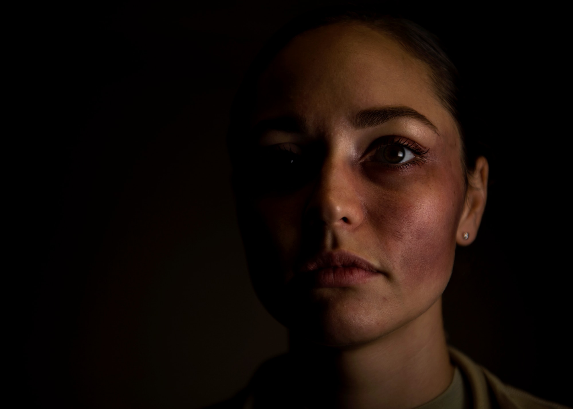 U.S. Air Force Tech. Sgt. Megan Lundgren, 52nd Air Mobility Squadron unit training manager, poses for a portrait while wearing moulage makeup at Spangdahlem Air Base, Germany, Oct. 17, 2018. Lundgren volunteered to simulate a victim of domestic violence for one day in support of the Black Eye Campaign. The social experiment utilized volunteers of varied age, rank, gender, ethnicity, occupation, and marital status to keep track of how the base community responded to signs of abuse. (U.S. Air Force photo by Airman 1st Class Valerie Seelye)