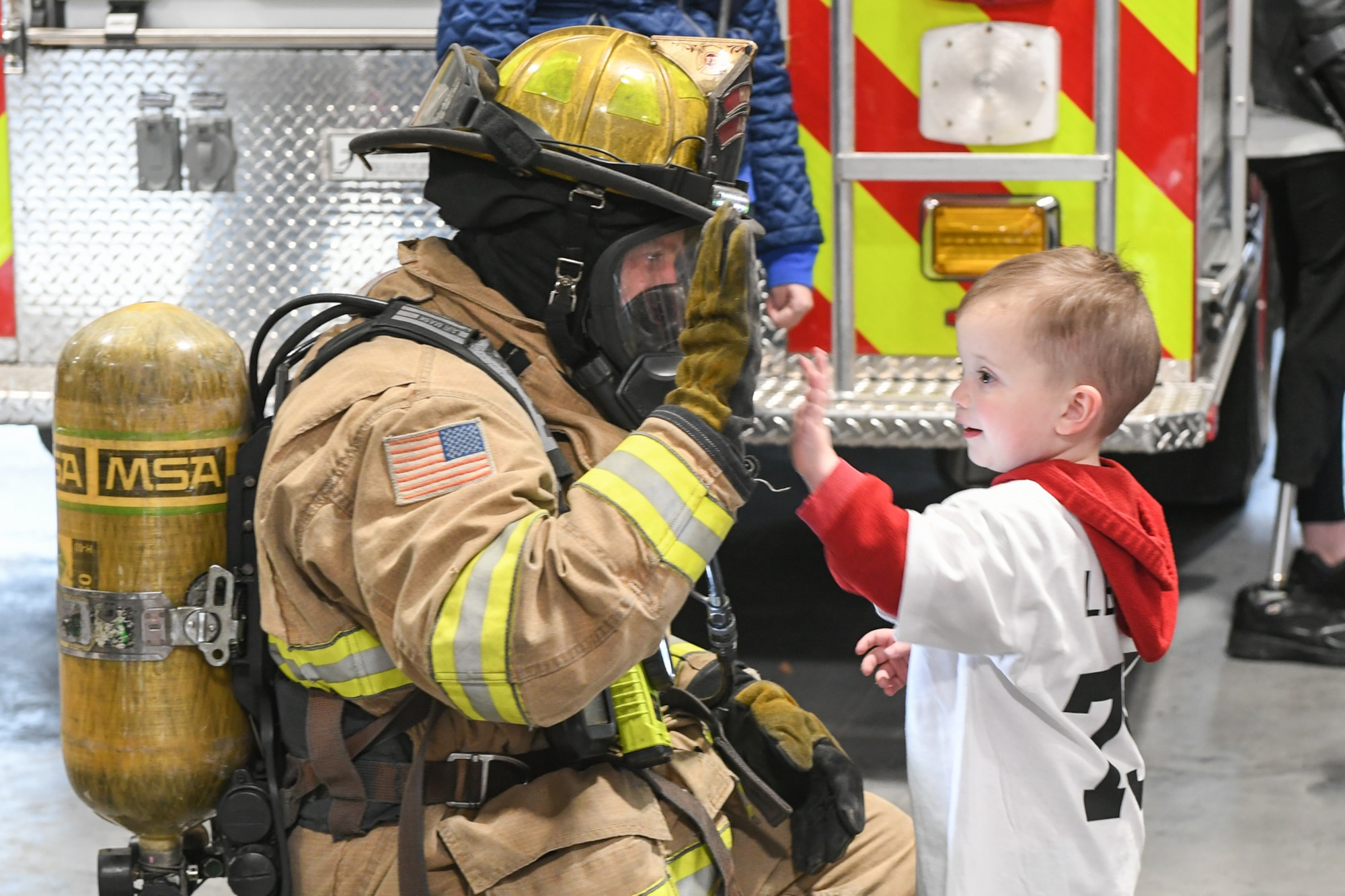 Clark Lenehan high-fives Duncan Hutchinson, a firefighter with 775th Civil Engineering Squadron, during a visit to the fire department Oct. 11, 2018, at Hill Air Force Base, Utah. The visit was part of a 75th Air Base Wing-hosted base tour for Make-A-Wish Utah children and their families. (U.S. Air Force photo by Cynthia Griggs)