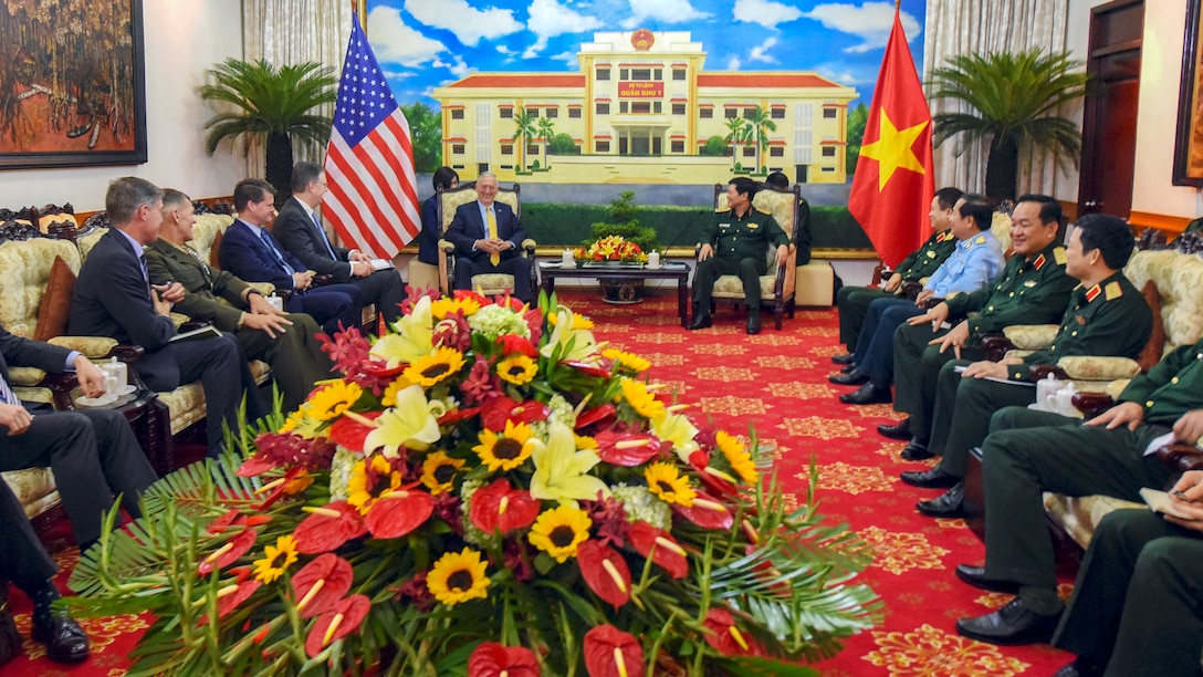 The staves of watch as Defense Secretary James N. Mattis and  Vietnamese Defense Minister meet in a formal room.