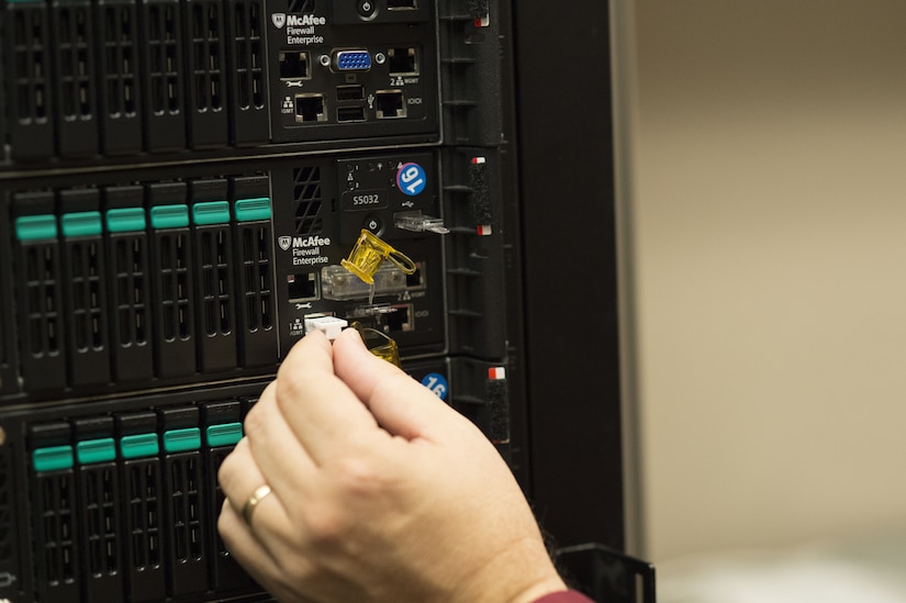 Photo of hand inserting PadJack device into an Ethernet port on a server.