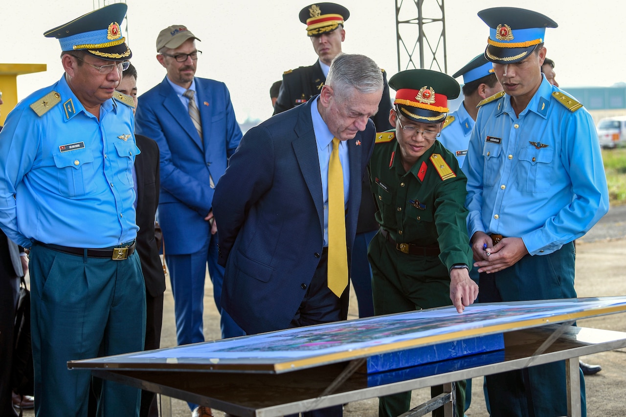 Defense Secretary James N. Mattis and Vietnamese officials look at a map of a dioxin-contaminated site.