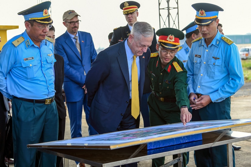 Defense Secretary James N. Mattis and Vietnamese officials look at a map of a dioxin-contaminated site.