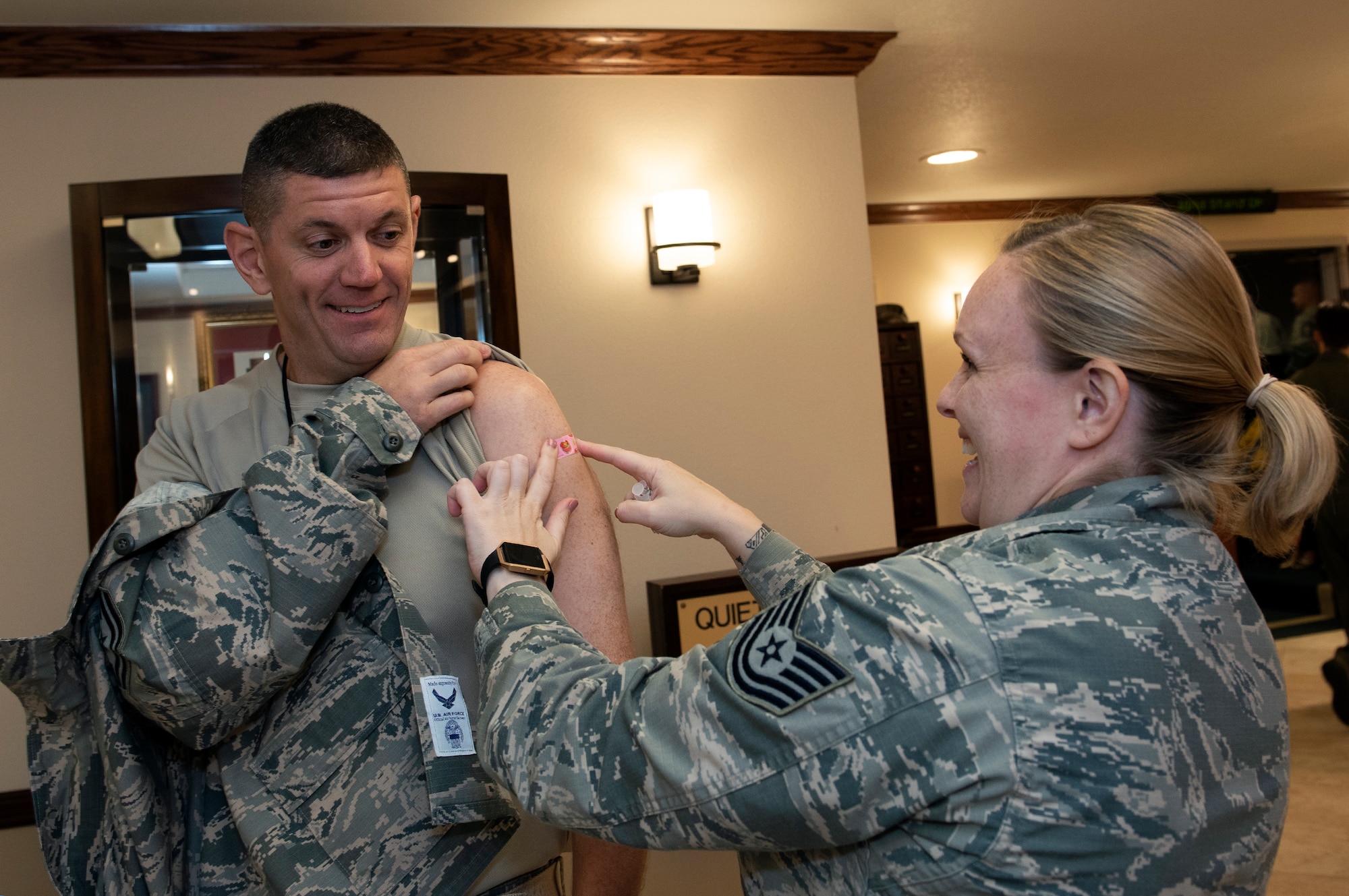 U.S. Air Force Chief Master Sgt. Derek Crowder, command chief, 60th Air Mobility Wing is administered his seasonal influenza vaccination by Tech. Sgt. Kelly Manibusan, non-commissioned officer in charge of the David Grant USAF Medical Center's Allergy/Immunology, Oct. 10, 2018, Travis Air Force Base, Calif.  (U.S. Air Force Photo by Heide Couch)