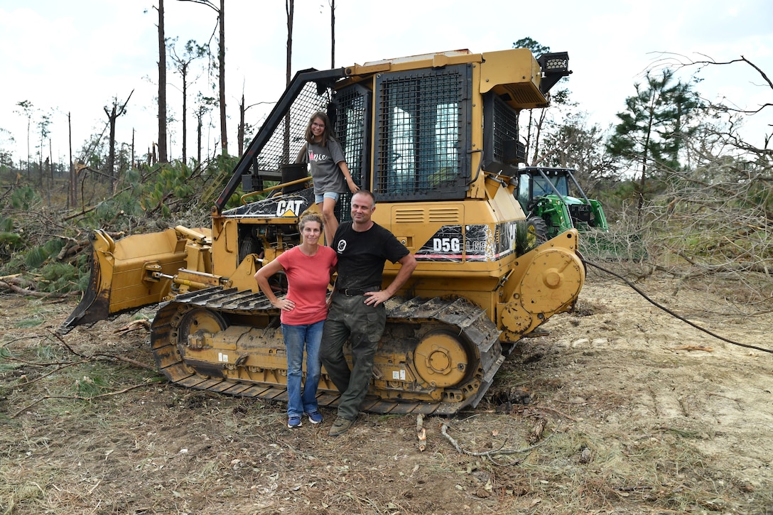 Kelly Bunting, U.S. Army Corps of Engineers Mobile District Park Ranger at the Lake Seminole Project, her husband Nate, and her daughter Norah, pose in front of their bulldozer in back of their house on Oct. 16, 2018 in Sneads, Fla. The Buntings survived Hurricane Michael by riding out the Category 4 storm in their bulldozer.