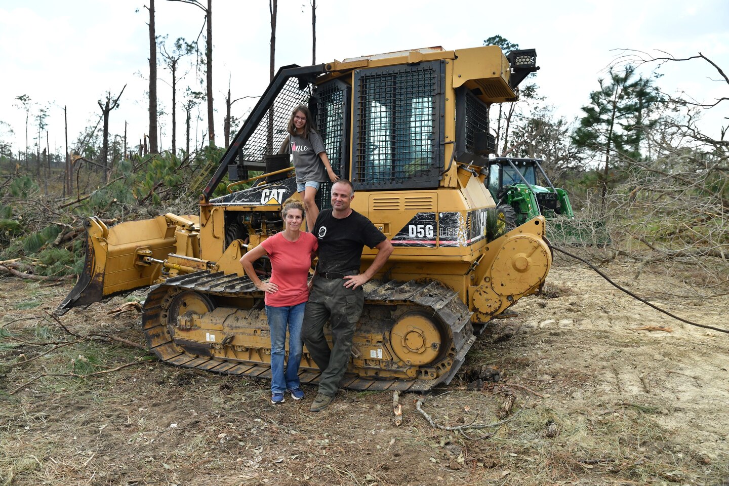 Kelly Bunting, U.S. Army Corps of Engineers Mobile District Park Ranger at the Lake Seminole Project, her husband Nate, and her daughter Norah, pose in front of their bulldozer in back of their house on Oct. 16, 2018 in Sneads, Fla. The Buntings survived Hurricane Michael by riding out the Category 4 storm in their bulldozer.