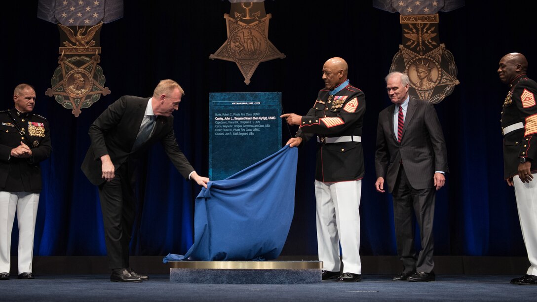 Deputy Defense Secretary Patrick M. Shanahan and Medal of Honor recipient retired Marine Corps Sgt. Maj. John L. Canley remove the curtain from Canley's Hall of Heroes plaque.
