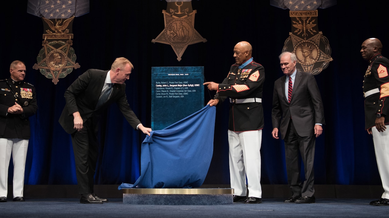 Deputy Defense Secretary Patrick M. Shanahan and Medal of Honor recipient retired Marine Corps Sgt. Maj. John L. Canley remove the curtain from Canley's Hall of Heroes plaque.