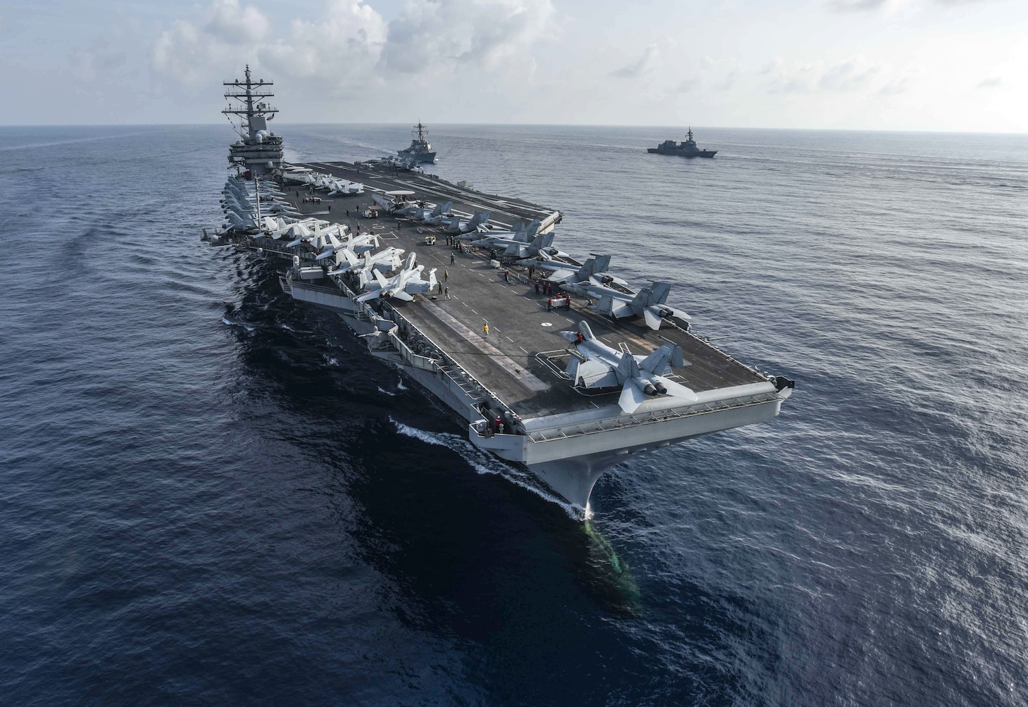 SOUTH CHINA SEA (Aug. 31, 2018) The aircraft carrier USS Ronald Reagan (CVN 76) and the guided-missile destroyer USS Milius (DDG 69), center, conduct a photo exercise with Japan Maritime Self-Defense Force ships. The Ronald Reagan Carrier Strike Group is forward-deployed to the U.S. 7th Fleet area of operations in support of security and stability in the Indo-Pacific region.