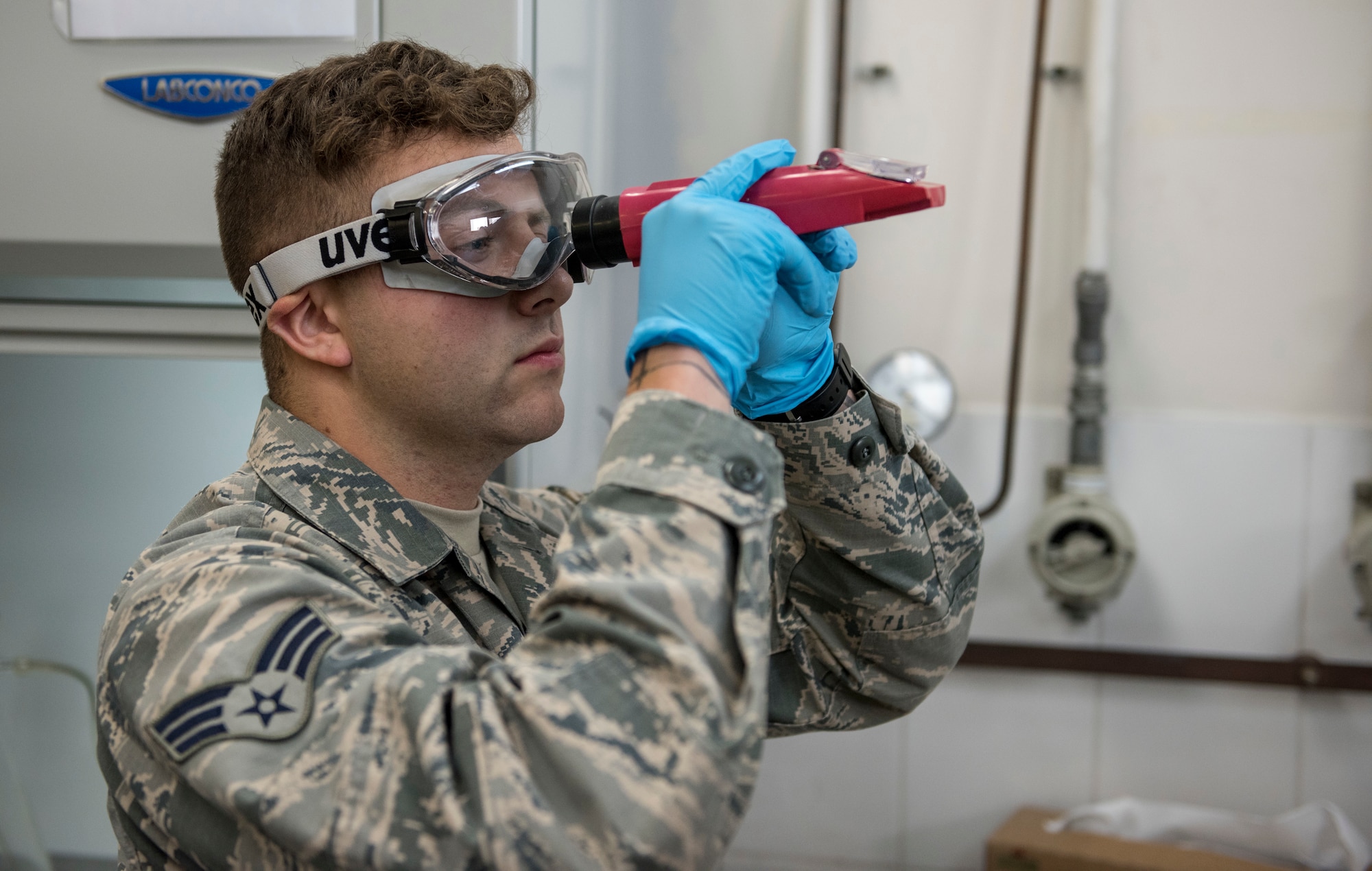 Logistics Airman checks a refractometer to help check a fuel system icing inhibitor.