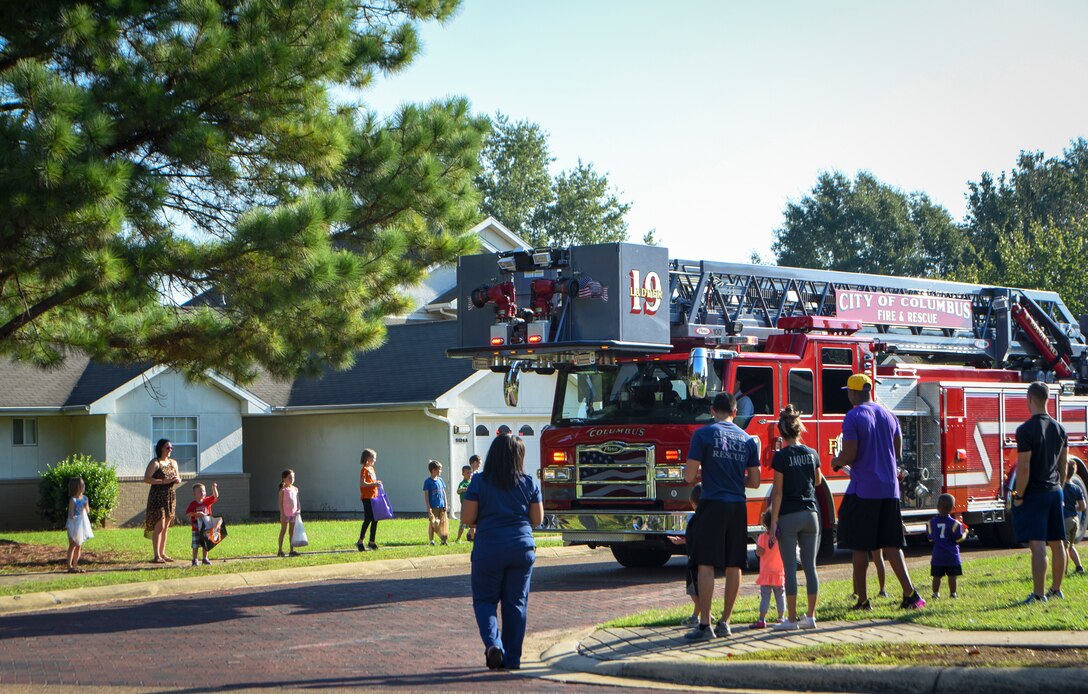 Residents of Magnolia Housing on Columbus Air Force Base, Mississippi, watch fire trucks pass by and toss out candy during a parade Oct. 6, 2018. The parade kicked off Fire Prevention Week for Columbus AFB and this year’s theme was “Be aware. Fire can happen anywhere.” (U.S. Air Force photo by Tech. Sgt. Christopher Gross)