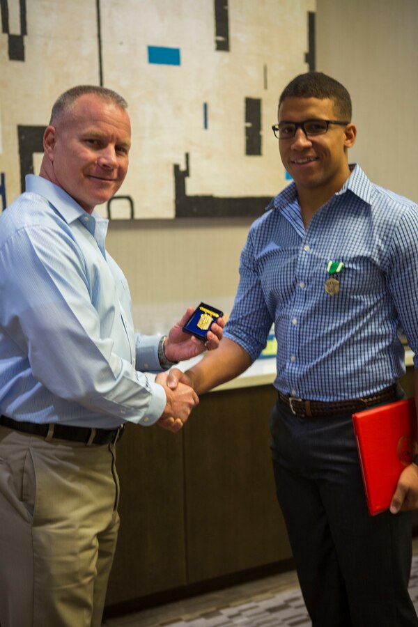 Sgt. James Ellis (right), a squad leader with 3rd Battalion, 23rd Marine Regiment, was awarded the Navy Marine Corps Commendation Medal and the title of 4th Marine Division Super Squad 2018 by Brig. Gen. Michael Martin (left), 4th MARDIV commanding general, for his leadership skills during the 2018 Super Squad Competition at the AC Hotel in New Orleans, Oct 17, 2018. The Super Squad Competition is designed to evaluate a 14-man infantry squad throughout an extensive field and live-fire evolution by competing in events that highlighted offensive/defensive operations, patrolling techniques, combat marksmanship, physical endurance and small unit leadership. (U.S. Marine Corps photo by Lance Cpl. Melany Vasquez/Released)