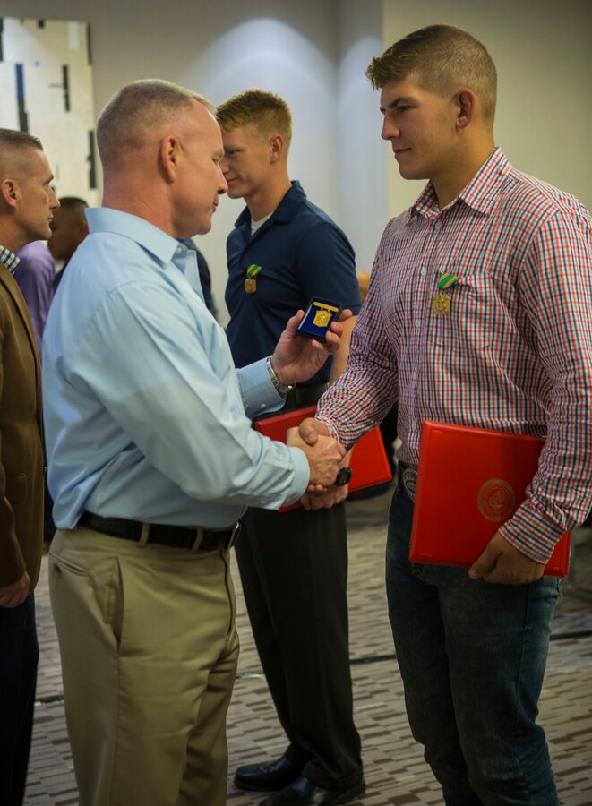 Lance Cpl. Cole Cunningham (right), a mortarman with 3rd Battalion, 23rd Marine Regiment, was awarded the Navy Marine Corps Achievement Medal and the title of 4th Marine Division Super Squad  2018 by Brig. Gen. Michael Martin (left), 4th MARDIV commanding general, for his leadership skills during the 2018 Super Squad Competition at the AC Hotel in New Orleans, Oct 17, 2018 . The Super Squad Competition is designed to evaluate a 14-man infantry squad throughout an extensive field and live-fire evolution by competing in events that highlighted offensive/defensive operations, patrolling techniques, combat marksmanship, physical endurance and small unit leadership (U.S. Marine Corps photo by Lance Cpl. Melany Vasquez/Released)