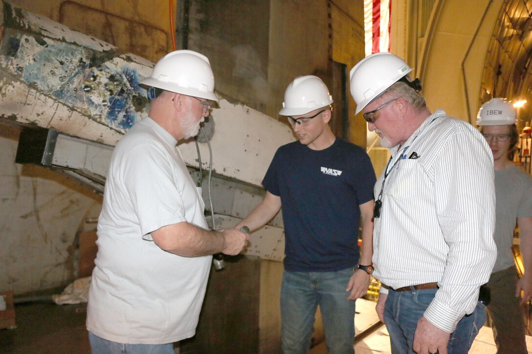 AEDC electricians Jimmy Newman, left, Andy Grissom, center, and Brian Roper, right, inspect the hookup cables for the pitch boom on the S-cart for the 16-foot Supersonic wind tunnel at Arnold Air Force Base. Pictured in back is Bradford Stirewalt looking on. (U.S. Air Force photo by Deidre Ortiz)