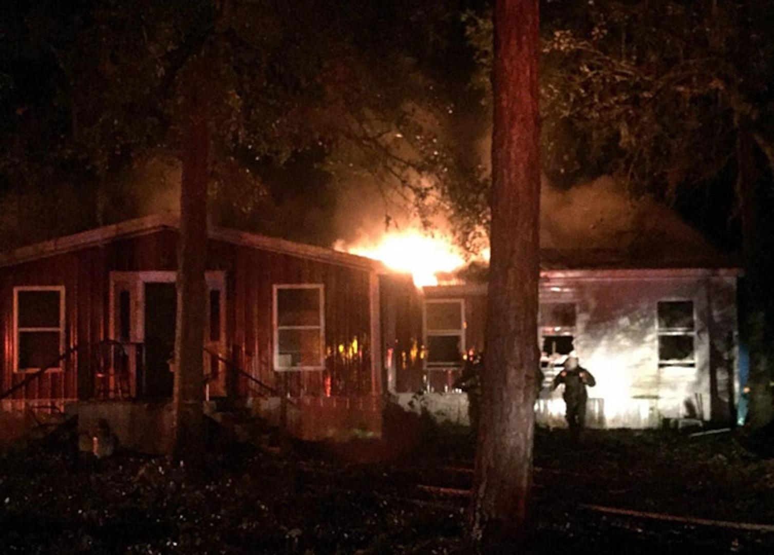 Georgia Army National Guard Sgt. Blake Mote of the Kennesaw, Ga.-based 190th Military Police Company emerges from a burning house after being relieved by Lieutenant Michael Smith of the Donalsonville Fire and Emergency Services Department. Mote, a firefighter and advanced emergency management technician with the Clayton County Fire and Emergency Management Services, was on patrol with his unit and first responders when they were alerted to respond to the fire.