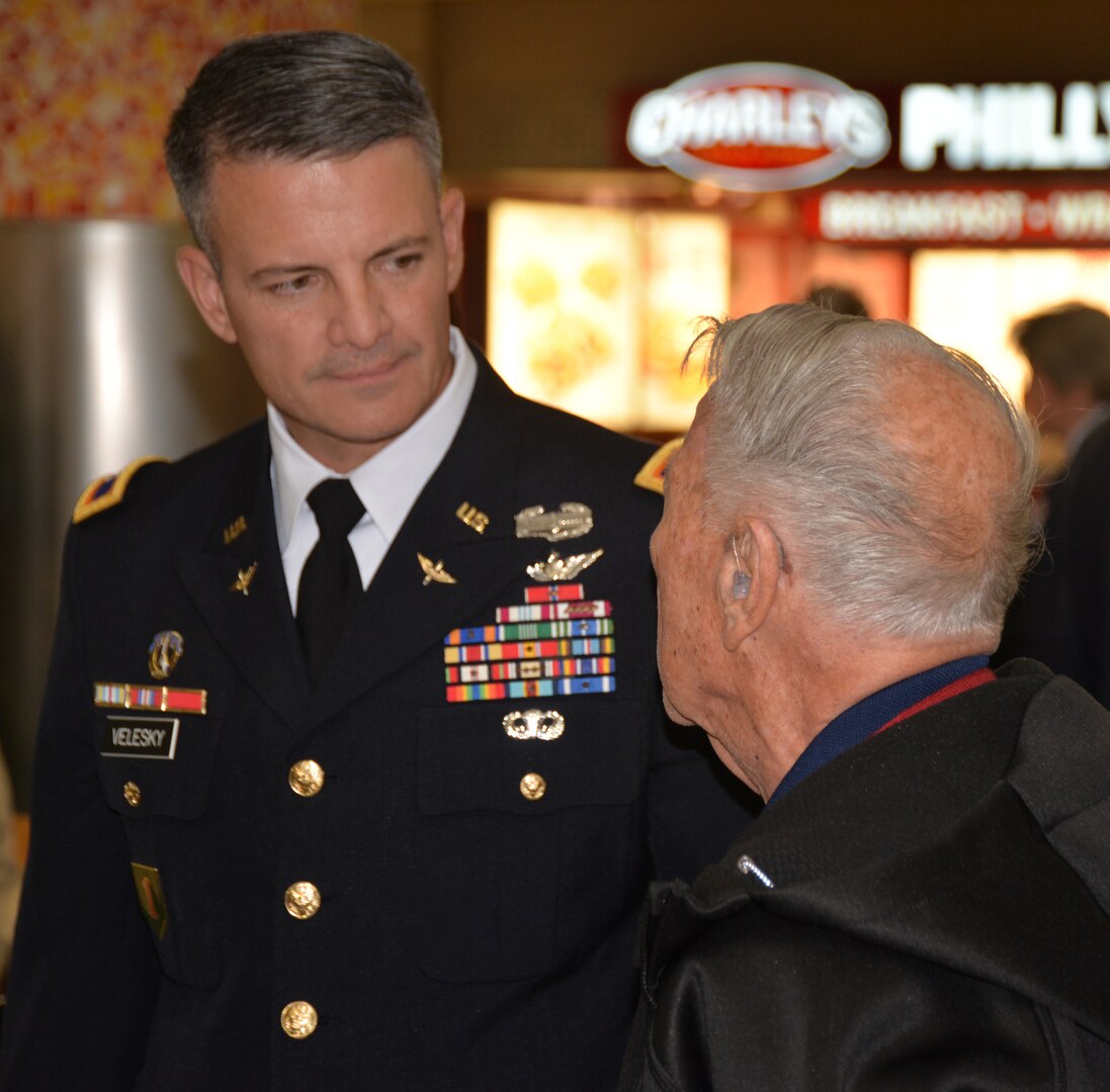 Army Col. Peter Velesky, vice commander, 502nd Air Base Wing and Joint Base San Antonio, speaks with a World War II veteran before the start of a sendoff ceremony at the San Antonio International Airport Oct. 17, which saw 40 WWII veterans take off for a trip to New Orleans to visit the National World War II Museum. The Soaring Valor program, sponsored by the Gary Sinise Foundation, helped send the veterans and 40 high school Student companions from Dallas, to the museum.