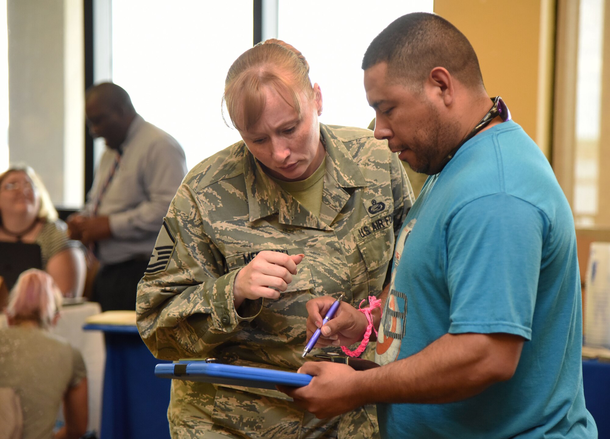 Master Sgt. Krista Mercadel, 81st Force Support Squadron personnel programs superintendent, provides assistance to Tech. Sgt. Alberto De La Garza, 325th Maintenance Squadron production supervisor assigned to Tyndall Air Force Base, Florida, during an open house for Hurricane Michael evacuees inside the Bay Breeze Event Center at Keesler Air Force Base, Mississippi, Oct. 16, 2018. Keesler offered assistance from various agencies that included the American Red Cross, finance, military family life counselors, Tricare, 81st Force Support Squadron services and more. (U.S. Air Force photo by Kemberly Groue)