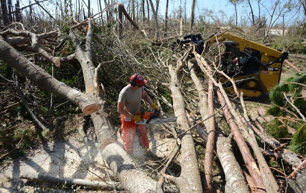 Staff Sgt. Christopher Lybrand, structures craftsman with the 202nd RED HORSE Squadron, trims a tree trunk into smaller logs Oct. 16, 2018, in Panama City, Fla. The RED HORSE team used chainsaws, skid steers and back hoes to unblock caused by damage from Hurricane Michael. (U.S. Air Force photo Courtesy Photo)