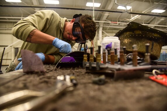 Senior Airman Cole Daniel, 22nd Maintenance Squadron aircraft structural journeyman, sands a KC-135 Stratotanker lower boom skin panel Oct. 17, 2018, at McConnell Air Force Base, Kan. If the dent measurements are not exceptional, then structural maintainers repair the damaged area. (U.S. Air Force photo by Airman 1st Class Alan Ricker)